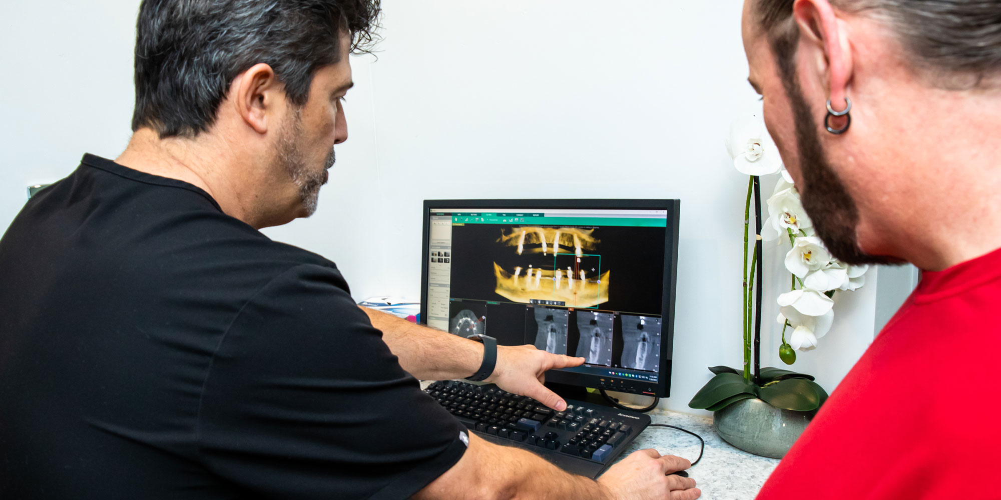 Doctor and patient discussing imaging display of dental implant procedure